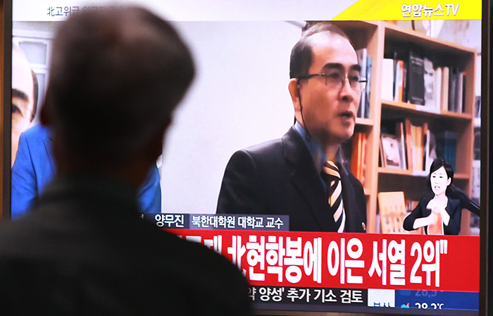 Thae Yong-ho, a minister at the North's embassy in London, defects to South Korea with his family on Aug. 17. South Korean citizens watch the news about his trip to the South.